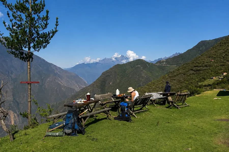 Trekkers resting with their packs at a viewpoint over the canyon