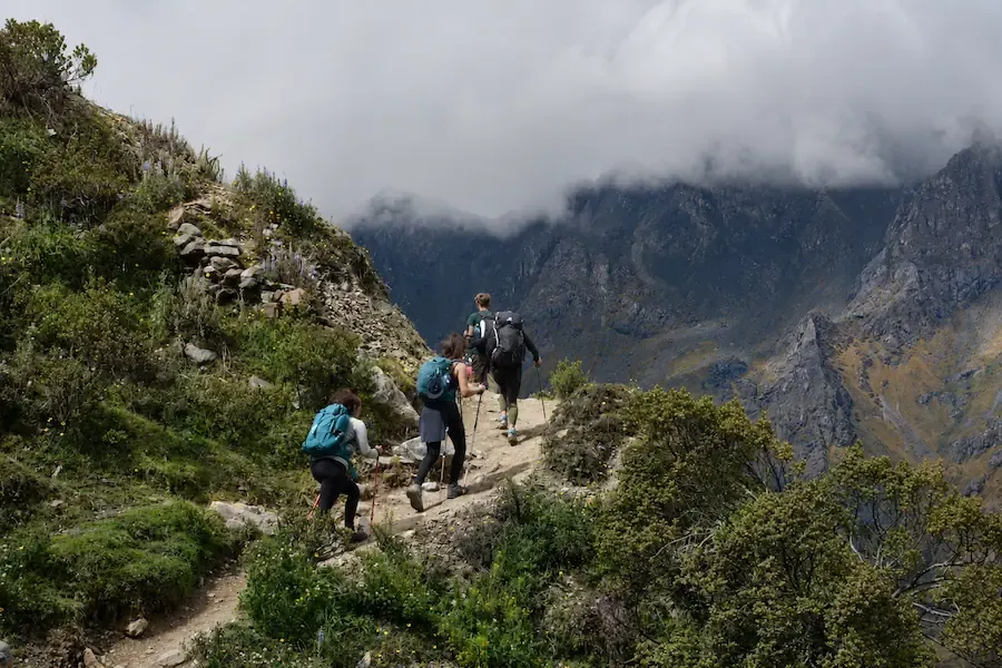 Hikers with poles and daypacks on the path up to the lake