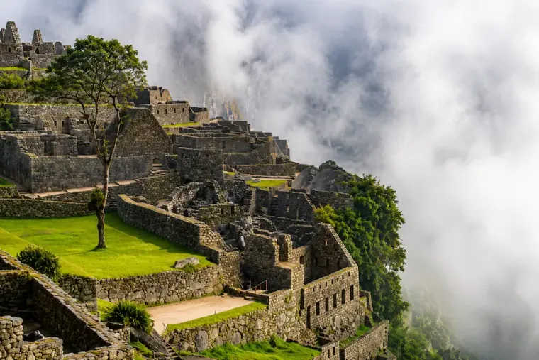 Terraces and walls of Machu Picchu with cloud passing over them
