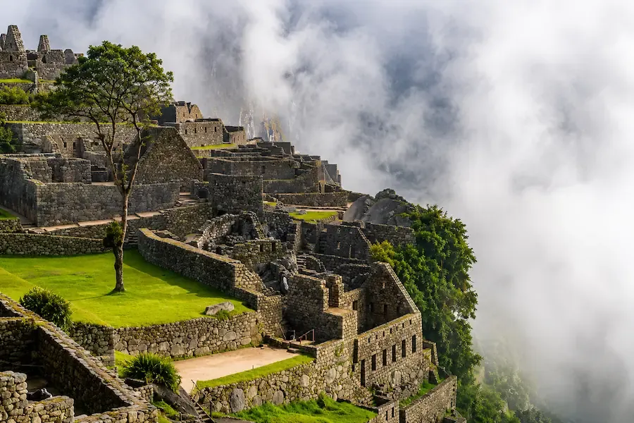 Terraces and walls of Machu Picchu with cloud passing over them