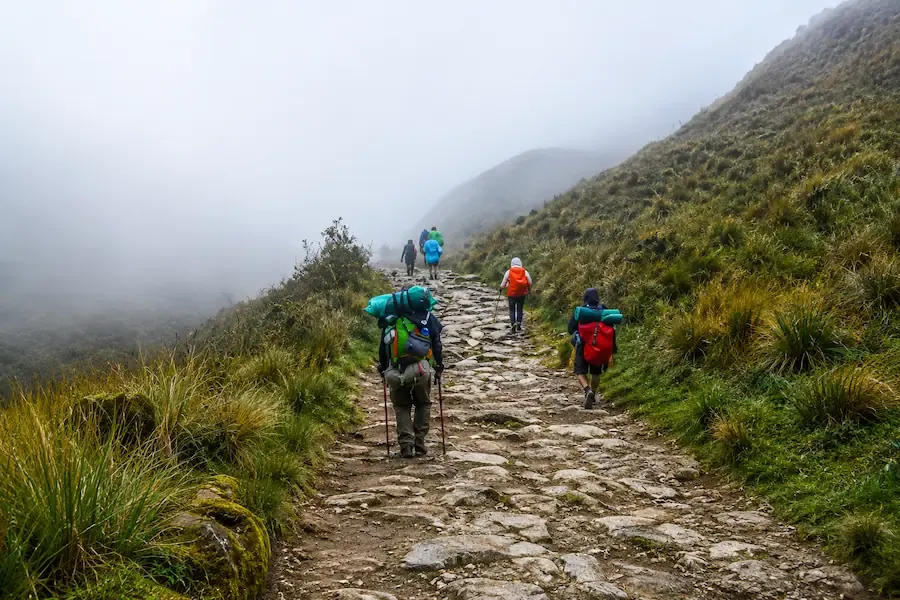 Hikers on original Inca paving in the mist