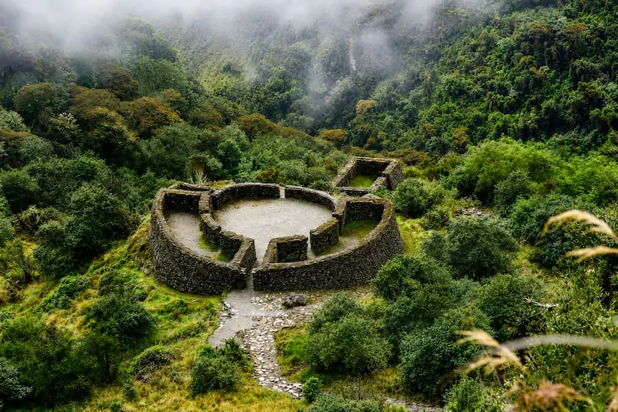 Round stone ruins surrounded by cloud forest