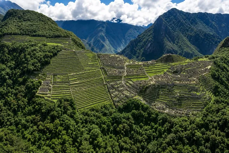 Machu Picchu and its terraces from above, ringed by forested peaks