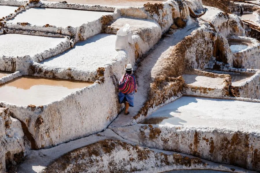 Worker gathering salt at the Maras salt pans