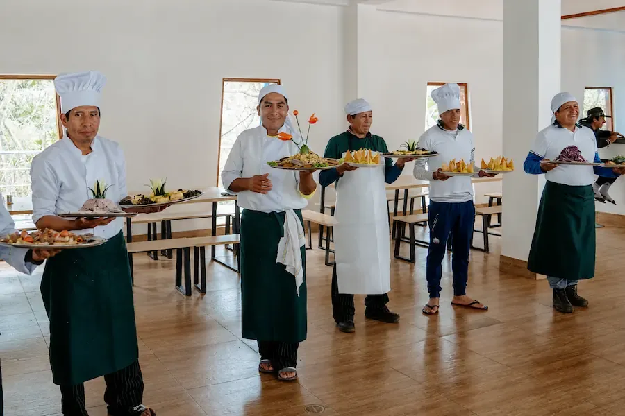 Camp cooks showing the dishes they prepared for the group